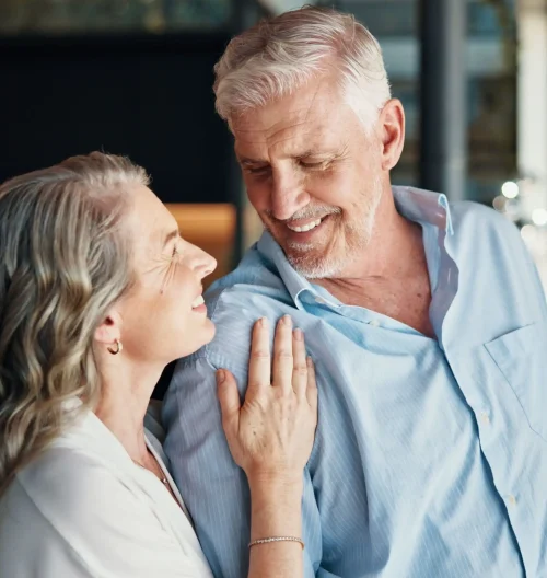 Window, bonding and couple in home, happy and mature people with love and romance for relationship. Anniversary, man and conversation with woman in house, nostalgia and commitment for marriage